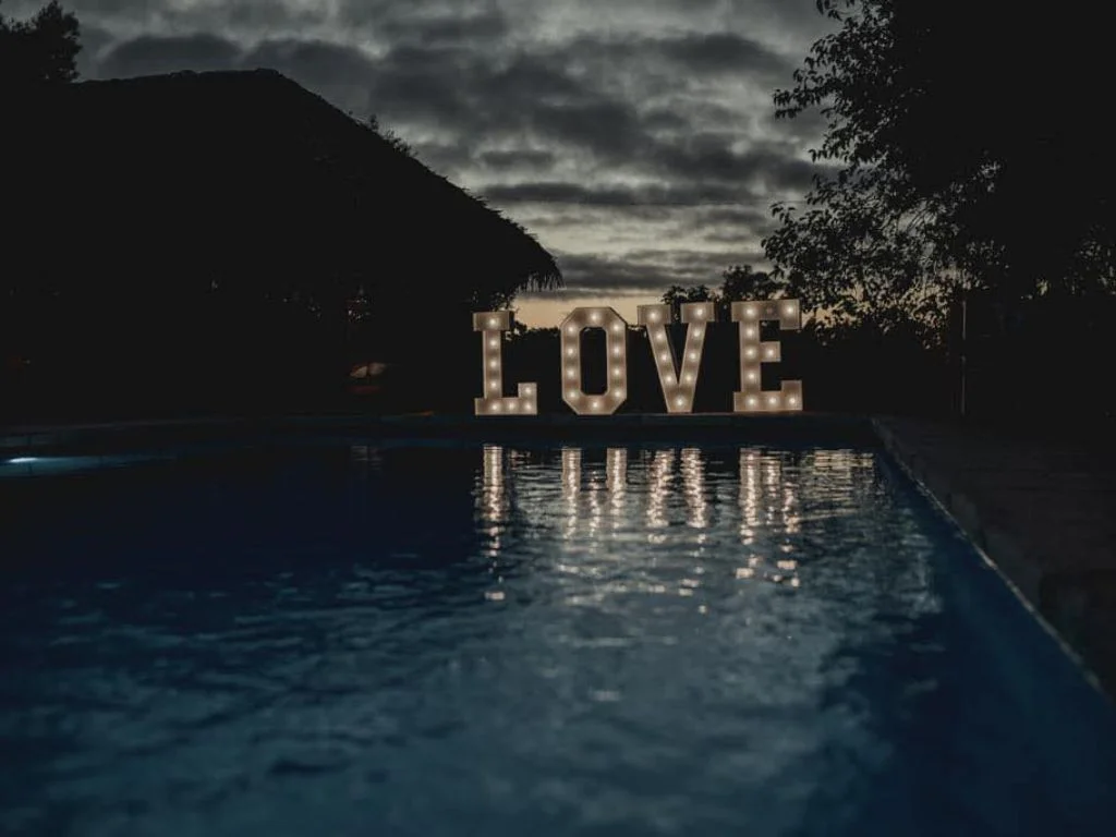 Piscina con cartel decorativo de ‘Love’ de fondo en Rafaella ChacraEventos, ideal para una celebración romántica