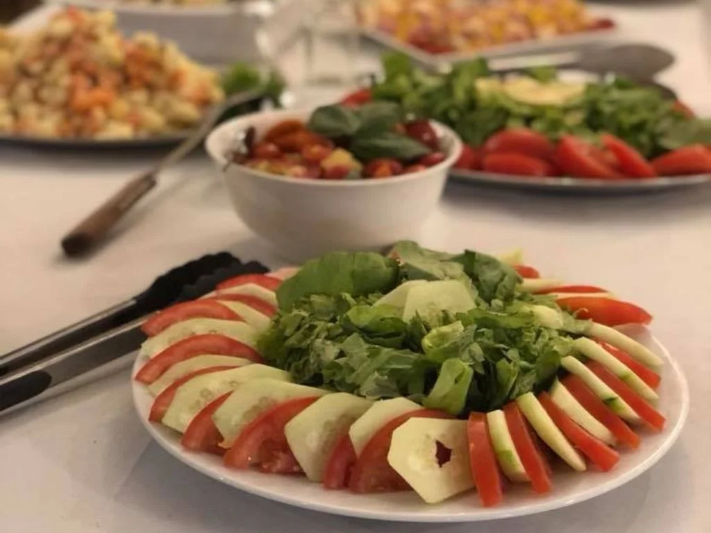 Mesas de ensaladas listas para que los invitados se sirvan en Rafaella ChacraEventos, ofreciendo una variedad fresca y colorida